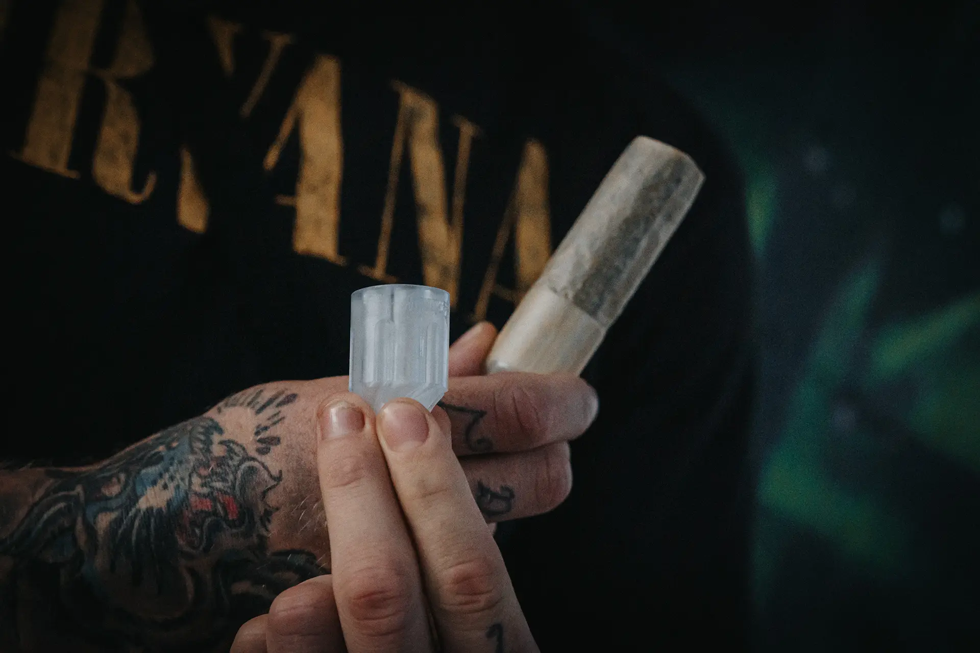 An MMA fighter holding a 6 Shooter Magnum Load in one hand and a joint using another 6 Shooter in the other hand